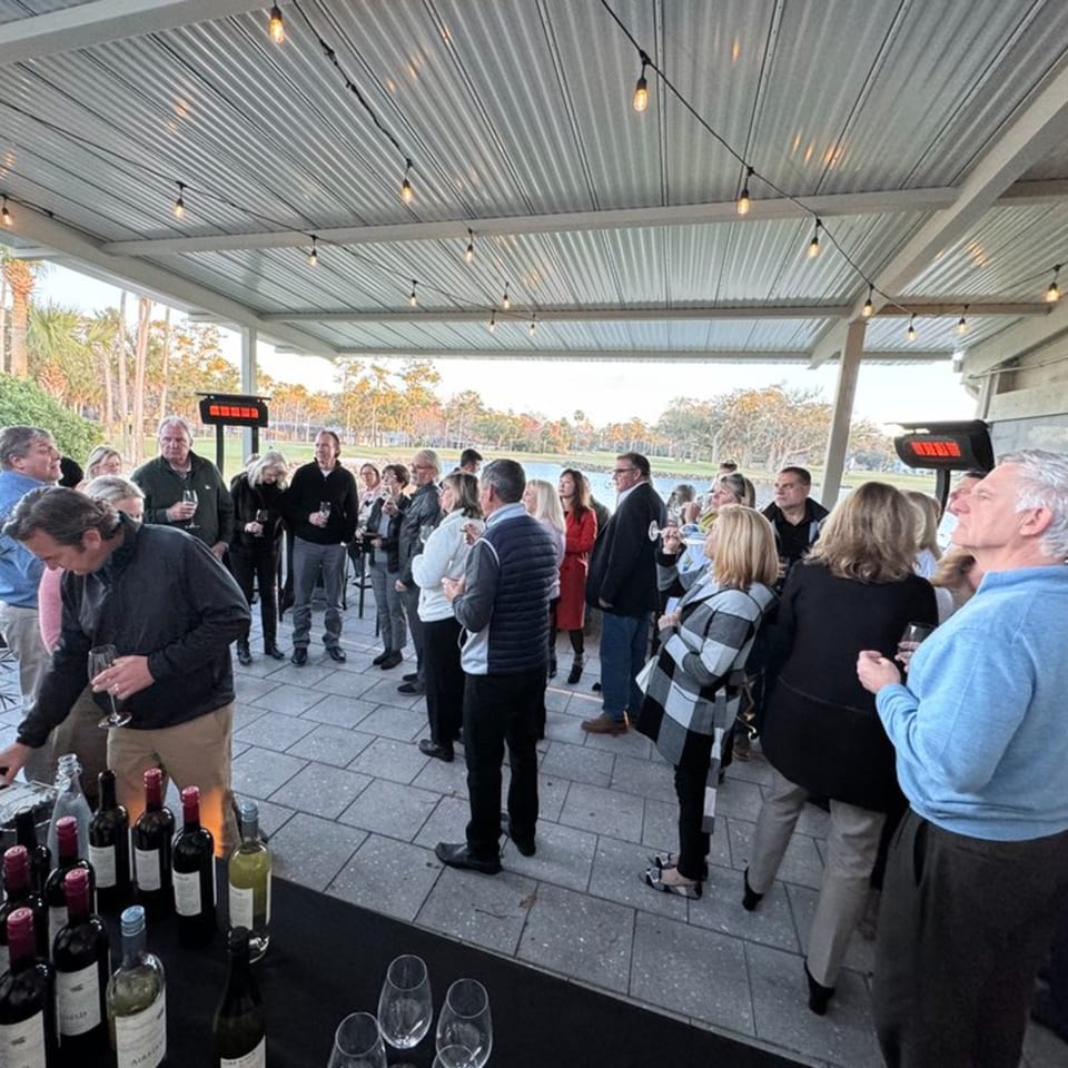 Guests mingle on Argyle Restaurant's outdoor patio, enjoying drinks and conversation under string lights.